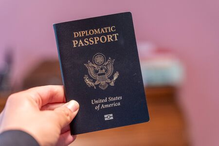 Hand holds up black Diplomatic Passport for the United States of Americaの写真素材