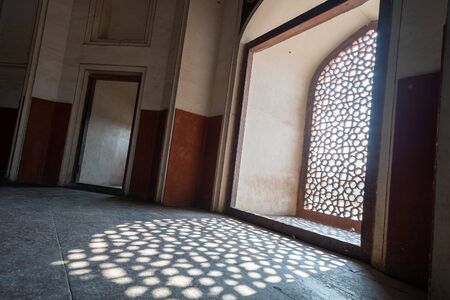 Intricate window lattice work creates a shadow on the floor of Humayans Tomb in Delhi Indiaのeditorial素材