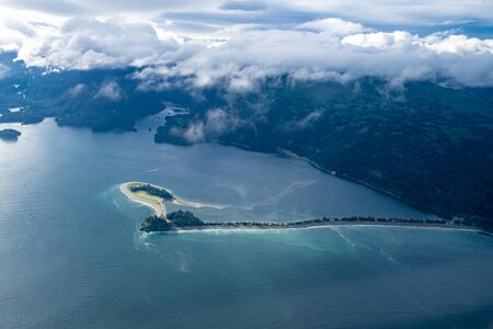 View of a spit of land near Seldovia Alaska, in the Kasitsna Bay. Aerial photography view with clouds and mountainsの写真素材