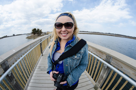 Fisheye lens view - female tourist explores the boardwalks of Assateague Island National Seashore in...