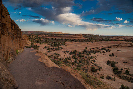 Trail to Delicate Arch is a rock ledge on the edge of a cliff in Arches National Park in Utah....