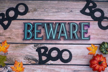 Beware boo Halloween background on wood backdrop with pumpkins and maple leaves. Fall and Halloween conceptの写真素材