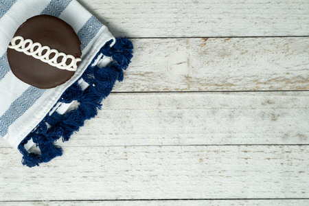 Chocolate swirled decorated cupcake with blue napkin on wood background