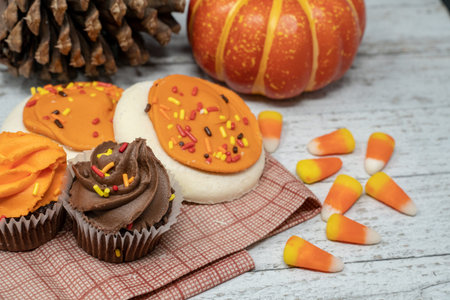 Autumn sweet desserts arrangement with focus on the chocolate cupcake. Sugar cookies and candy corn...
