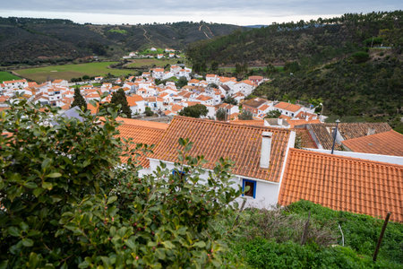 Overlook from a hill, looking over the rooftops of houses and buildings of Odeceixe, Portugal, a...