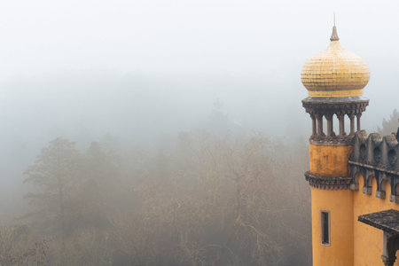 Detail view of a yellow dome column at Pena Palace (Palacio da Pena) fully engulfed in fog with poor...
