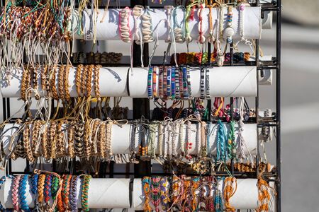 Handwoven embroidered bracelets, necklaces and other handicraft jewelry for sale at a Portugal marketの写真素材