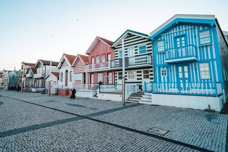 Costa Nova, Portugal - January 19, 2020: Adorable striped beach houses line the street of the resort town in winterの写真素材