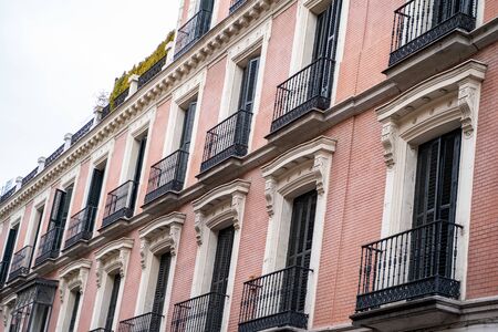 Beautiful building with pink facade and balconies in Madrid Spainの写真素材