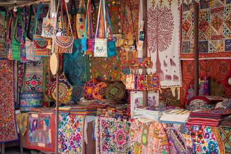 Vibrant, colorful market stall selling embroidered handicrafts such as pillow cases, tote bags, and...