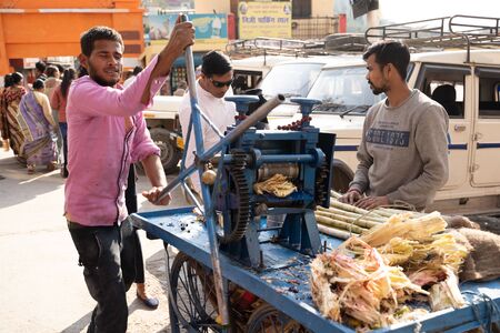 Rishikesh, India - Feburay 22, 2020: Young Indian men prepare fresh sugarcane juice on the street with a juicer cartのeditorial素材