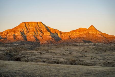 Alpenglow on badlands mountain cliffs in Eastern Montana during sunrise, near Miles City, MTの写真素材