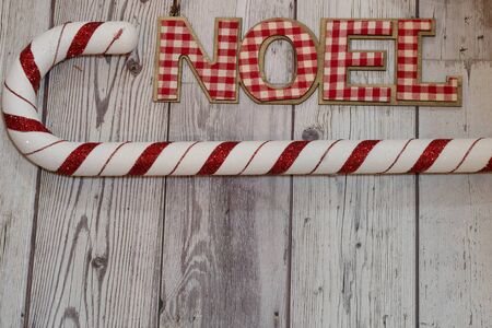 Christmas holiday flatlay with Noel word in red plaid, decorative candy cane on wood background. Useful for rustic backgroundsの写真素材