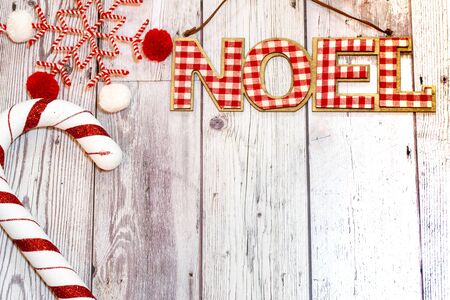 Christmas holiday flatlay with Noel word in red plaid, decorative candy cane and a twine snowflake. Useful for rustic backgroundsの写真素材
