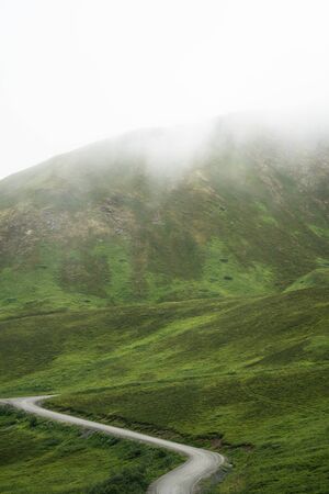 The dirt gravel road to Hatcher Pass, near Palmer Alaska and Independence Mine on a foggy misty summer dayの写真素材
