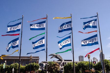 Flags for Pier 39 in Fisherman's Wharf San Francisco against a blue sky.の写真素材