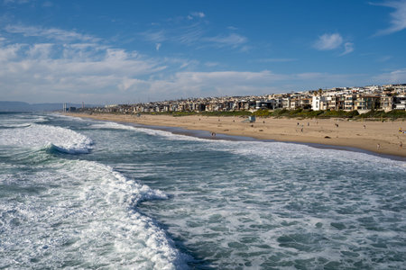 Late afternoon cityscape view of Manhattan Beach California, as seen from the pier, as waves from...