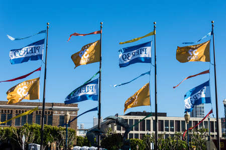 JULY 6 2017 - SAN FRANCISCO, CALIFORNIA: Flags celebrating Pier 39's 39th anniversary fly against a blue sky.のeditorial素材