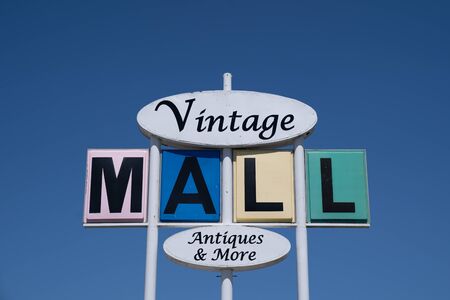 Mankato, Minnesota - June 6, 2020: Sign for an abandoned antique mall called Vintage Mall. Retro sign against blue sky in mid century modern styleの写真素材