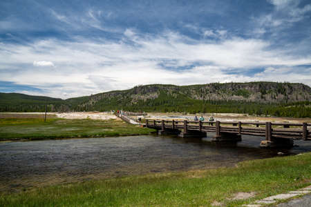 Yellowstone National Park, Wyoming - June 27, 2020: Tourists cross the pedestrian bridge over to Biscuit Basin geothermal area to view hot springsのeditorial素材