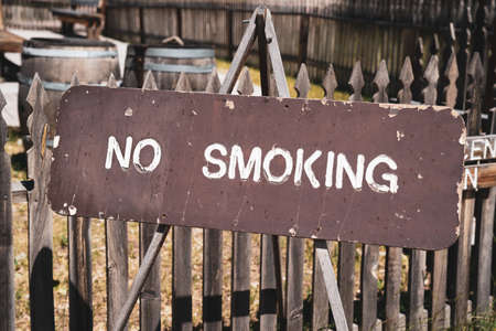 Wooden No Smoking sign posted to a fenceの写真素材