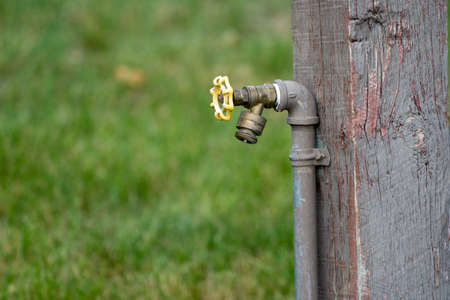 Outdoor water spigot fountain attached to a wooden porch, useful for campersの写真素材