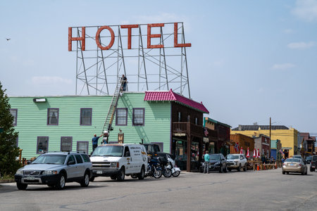 Fairplay, Colorado - September 16, 2020: Worker crew using a ladder repairs the neon sign for a downtown hotelのeditorial素材