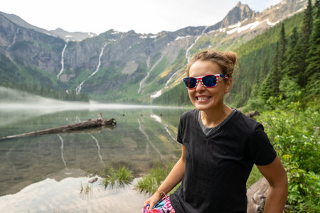 Adult woman hiker smiles and poses at Avalanche Lake in Glacier National Parkの写真素材