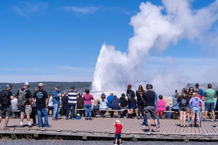 Wyoming, USA - August 10, 2021: Crowds of tourists wait along the boardwalks for Old Faithful to erupt in Yellowstone National Parkのeditorial素材