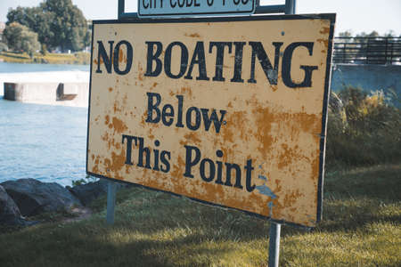 Caution signs for no swimming or boating in Idaho Falls Idaho, near the waterfall and dam of the riverの写真素材