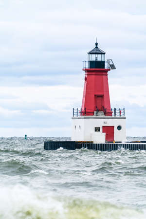Menominee Pierhead Lighthouse at Ann Arbor Park, as choppy waves of Lake Michigan crash ashoreの写真素材