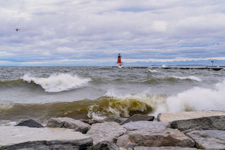 Menominee Pierhead Lighthouse at Ann Arbor Park, as choppy waves of Lake Michigan crash ashoreの写真素材