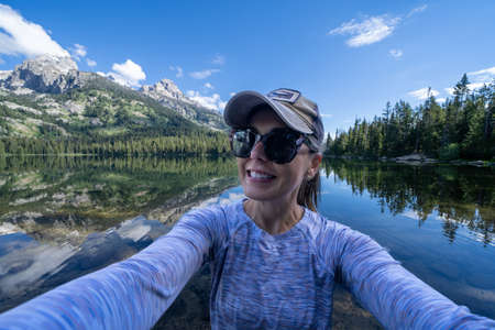 Happy hiker woman takes a selfie while at Bradley Lake in Grand Teton National Park Wyomingの写真素材