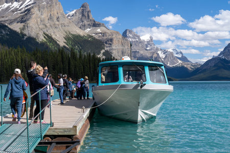Jasper, Alberta, Canada - July 13, 2022: Tourists line up on the dock to board a boat ride as they depart from Spirit Island on Maligne Lakeのeditorial素材
