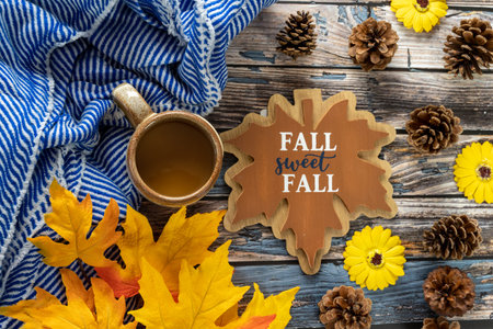 Fall cozy coffee and blue striped blanket flatlay background, with pine cones, maple leaves and...