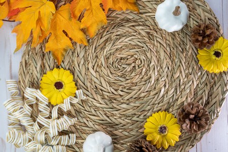 Top down fall flatlay with sunflowers, pine cones, ribbon, white pumpkins and leaves arrangement in a circleの写真素材