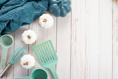 Baking and cooking top down flat lay concept in shades of blue and turquoise. Spatula, white pumpkins, blanket, and measuring cups with whisk.の写真素材
