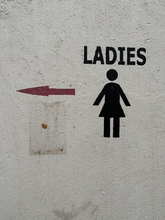 Hand painted wall sign for directions to a ladies restroom or bathroomの写真素材
