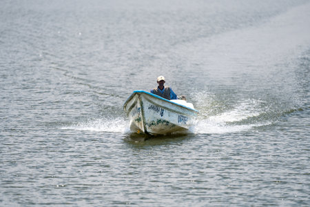Lake Naivasha, Kenya - March 4, 2023: Man captains a speedboat on the lake, creating a wake behind himのeditorial素材