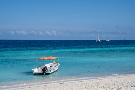 Zanzibar, Tanzania - March 16, 2023: Small boat docked near the beach, in crystal clear turquoise waterのeditorial素材