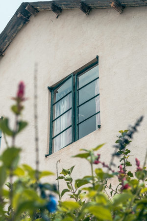 Beautiful window of a cottage home, surrounding by a garden
