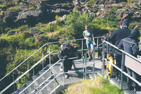Thingvellir National Park, Iceland - July 9, 2023: Tourists prepare to snorkel between the two tectonic plates at the steps to enter the cold water at Silfraのeditorial素材