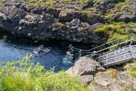 Thingvellir National Park, Iceland - July 9, 2023: Tourists prepare to snorkel between the two tectonic plates at the steps to enter the cold waterのeditorial素材