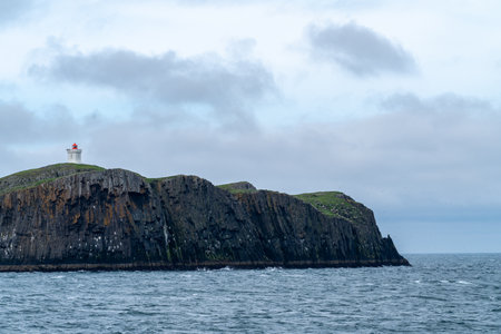 Lighthouse on ElliÃ°aey (ELLIDAEY) Island, with basalt cliffs on BreidafjÃ¶rdur Bayの写真素材