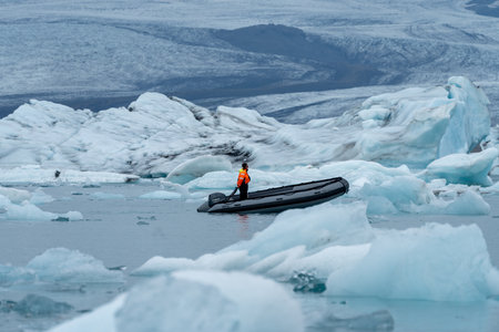 Jokulsarlon, Iceland - July 7, 2023: Man in a rib boat clears ice chunks in the Jokulsarlon glacial lagoon in Icelandのeditorial素材