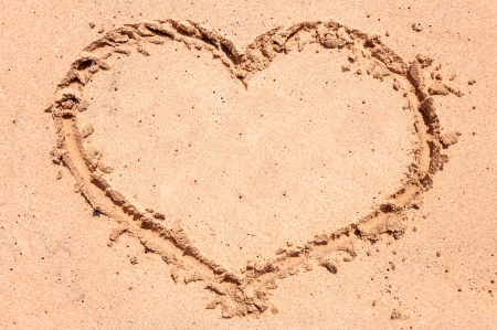 Heart drawn in sand on the beachの写真素材