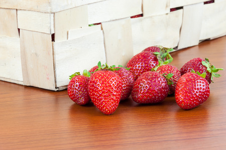 Closeup of fresh strawberries in front of a basketの写真素材