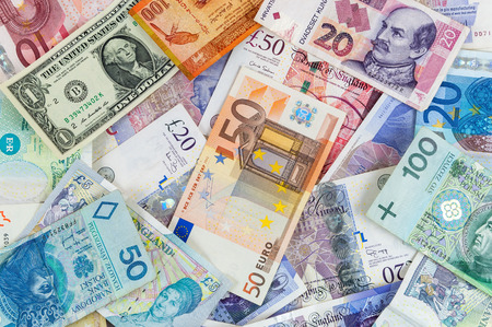Background made of different currencies banknotes - pile of moneyの写真素材