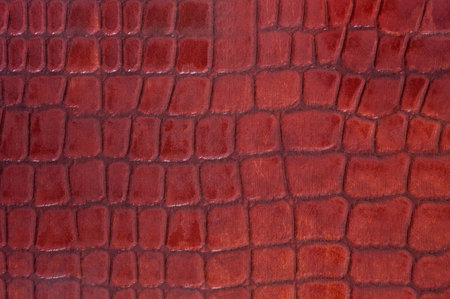 Red colored crocodile leather texture as abstract background