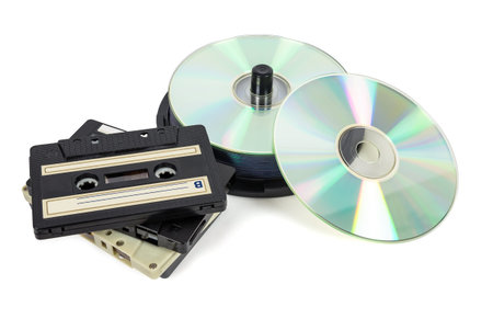 Stacks of CDs on spool and audio tapes isolated on white background